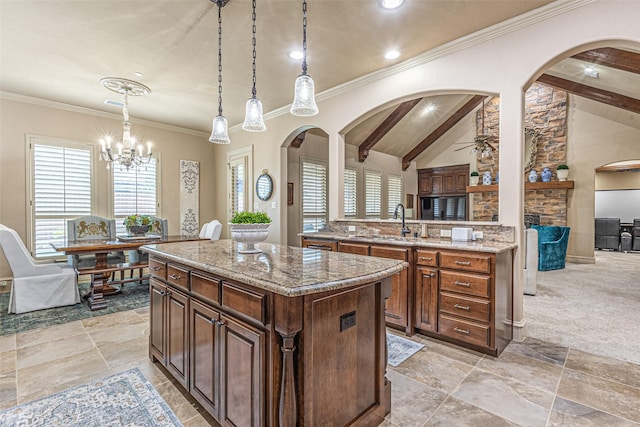 4230 Indian Creek Ln, Frisco, TX 75033 - kitchen featuring a sink, a kitchen island, arched walkways, light stone countertops, and crown molding