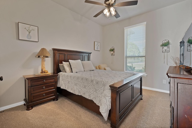 bedroom featuring baseboards, light carpet, and ceiling fan