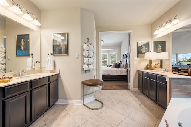 1005 Mallard Lakes Dr, Mckinney, TX 75072 - full bathroom featuring connected bathroom, two vanities, tile patterned floors, and baseboards