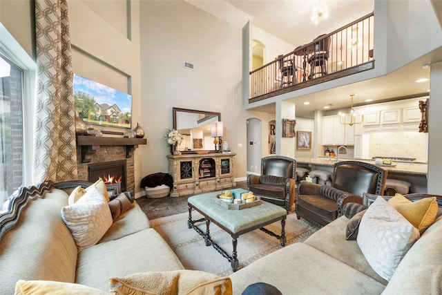 1005 Mallard Lakes Dr, Mckinney, TX 75072 - living room featuring baseboards, a high ceiling, a fireplace, and a chandelier