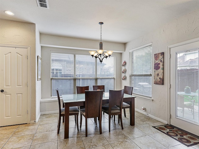 2420 Forest Gate Dr, Little Elm, TX 75068 - dining room with a chandelier, plenty of natural light, a textured wall, light tile patterned floors, and baseboards
