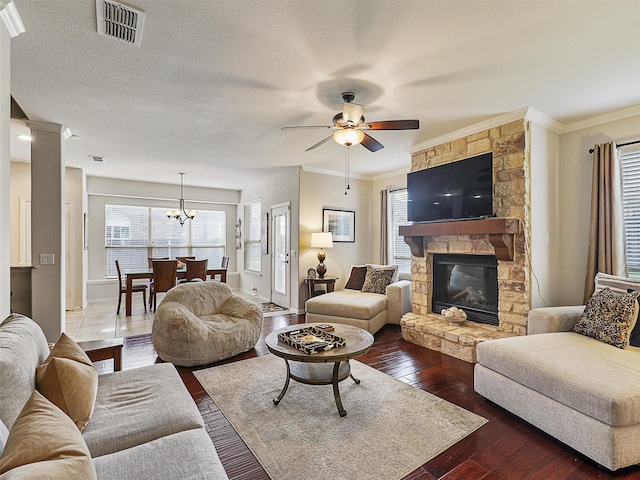 2420 Forest Gate Dr, Little Elm, TX 75068 - living room featuring a stone fireplace, a ceiling fan, dark wood-style floors, crown molding, and baseboards