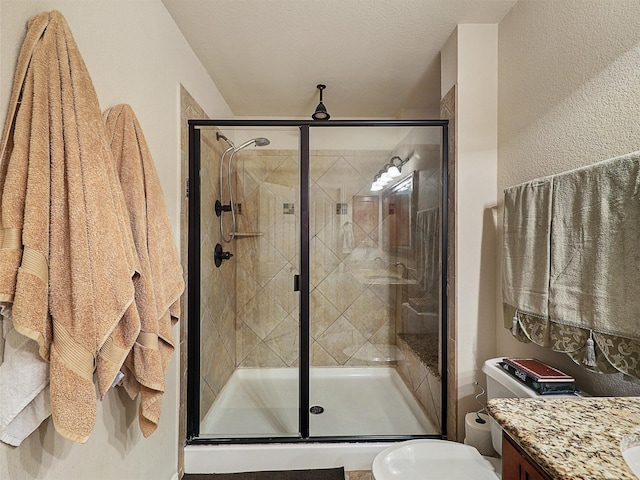 2420 Forest Gate Dr, Little Elm, TX 75068 - full bathroom with vanity, toilet, a stall shower, and a textured wall