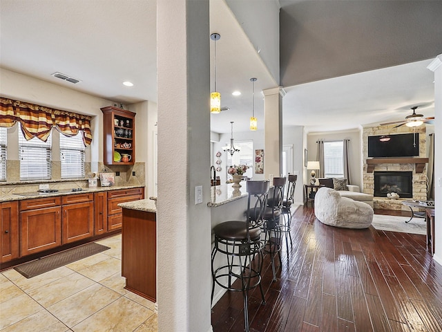 2420 Forest Gate Dr, Little Elm, TX 75068 - bar area with ceiling fan, a stone fireplace, decorative light fixtures, black electric cooktop, and backsplash