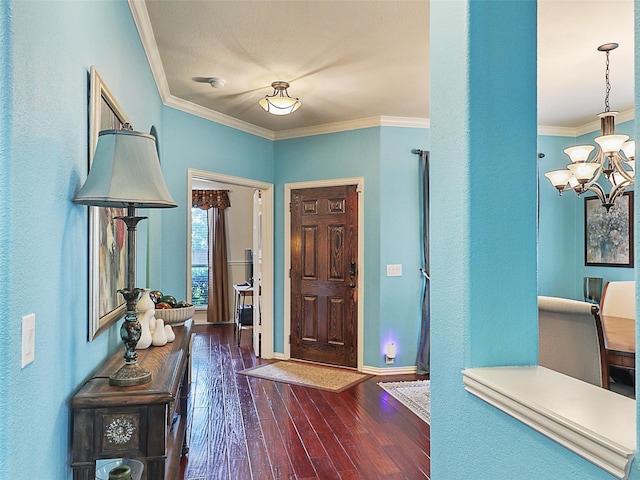 2420 Forest Gate Dr, Little Elm, TX 75068 - foyer entrance with a chandelier, crown molding, dark wood finished floors, baseboards, and a textured wall