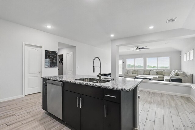 1036 Fairfax Dr, Godley, TX 76044 - kitchen with dishwasher, a sink, dark cabinetry, ceiling fan, and a kitchen island with sink