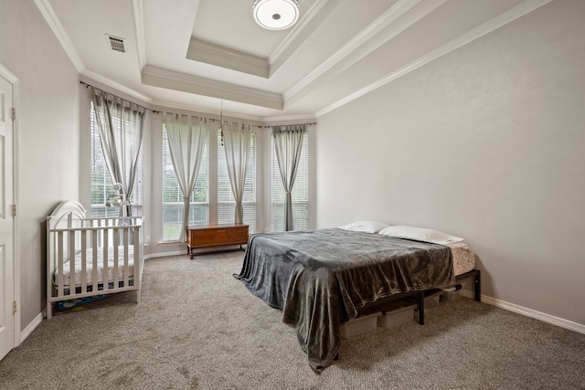 bedroom featuring a tray ceiling, visible vents, ornamental molding, and carpet