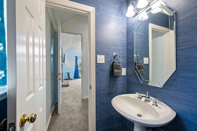 bathroom featuring baseboards, a chandelier, and a sink
