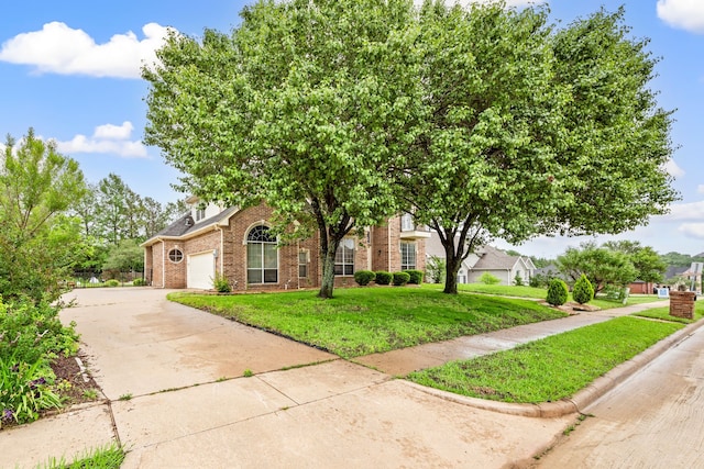 obstructed view of property with an attached garage, driveway, a front lawn, and brick siding