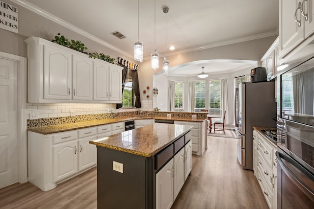 kitchen featuring white cabinets, a peninsula, light wood-style flooring, and visible vents