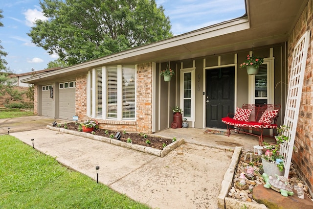 entrance to property with covered porch, driveway, and brick siding