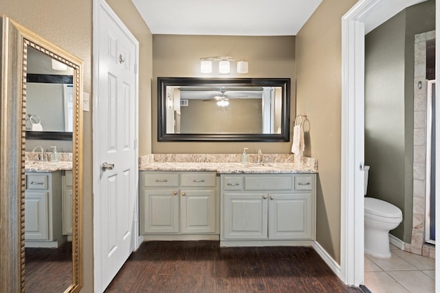 full bathroom featuring a ceiling fan, wood finished floors, vanity, baseboards, and toilet