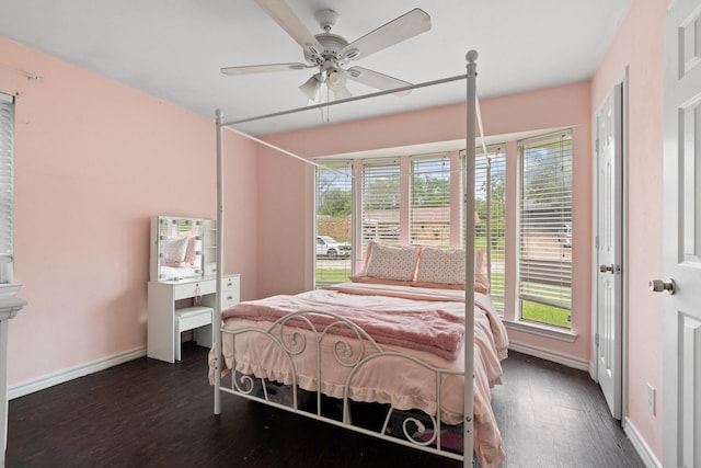 bedroom featuring baseboards, multiple windows, a ceiling fan, and dark wood-style flooring