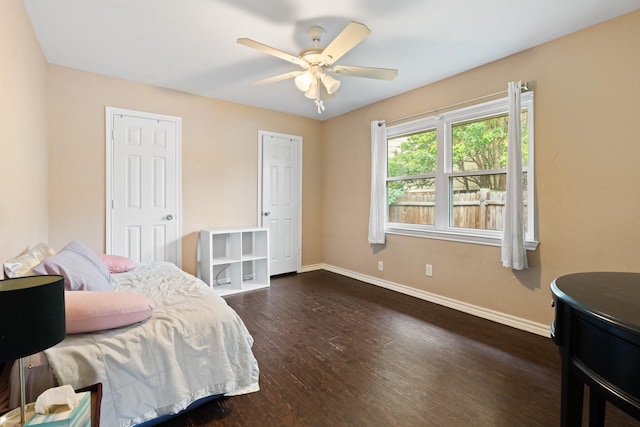 bedroom featuring a ceiling fan, baseboards, and dark wood-type flooring