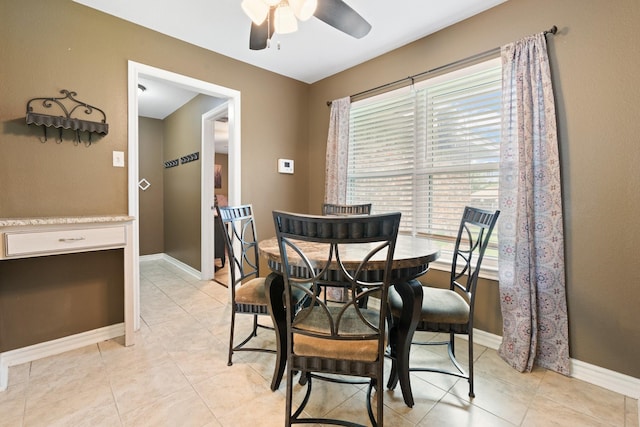 dining space featuring light tile patterned floors, baseboards, and ceiling fan
