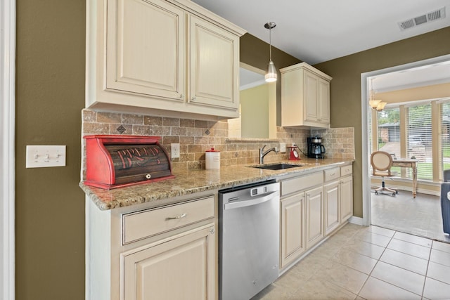 kitchen featuring visible vents, tasteful backsplash, dishwasher, a sink, and cream cabinetry