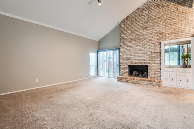 unfurnished living room with high vaulted ceiling, a brick fireplace, carpet flooring, baseboards, and crown molding