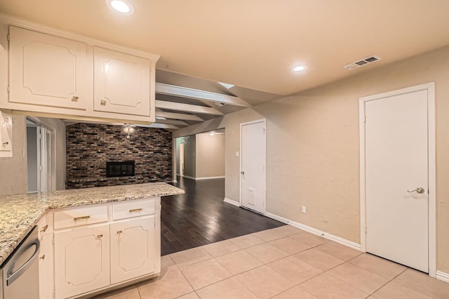 kitchen featuring dishwasher, white cabinetry, baseboards, light tile patterned floors, and visible vents