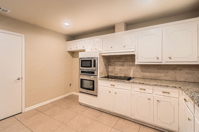 kitchen with appliances with stainless steel finishes, white cabinetry, light tile patterned floors, backsplash, and visible vents