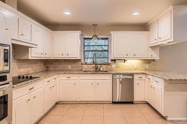 kitchen with backsplash, stainless steel appliances, white cabinetry, and a sink