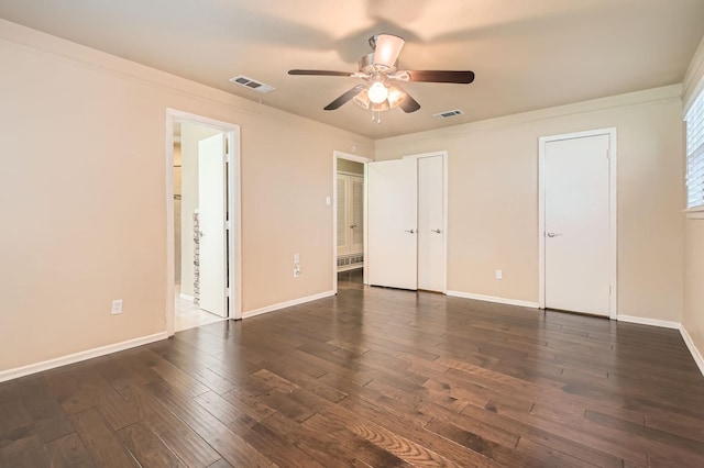 unfurnished bedroom with dark wood-style flooring, baseboards, and visible vents