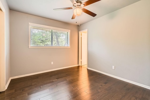 empty room with baseboards, ceiling fan, and dark wood-style floors
