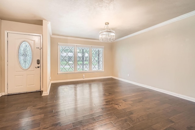 entrance foyer featuring baseboards, a chandelier, dark wood-style floors, and ornamental molding