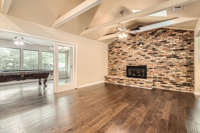 unfurnished living room featuring a fireplace, beamed ceiling, a ceiling fan, and wood finished floors