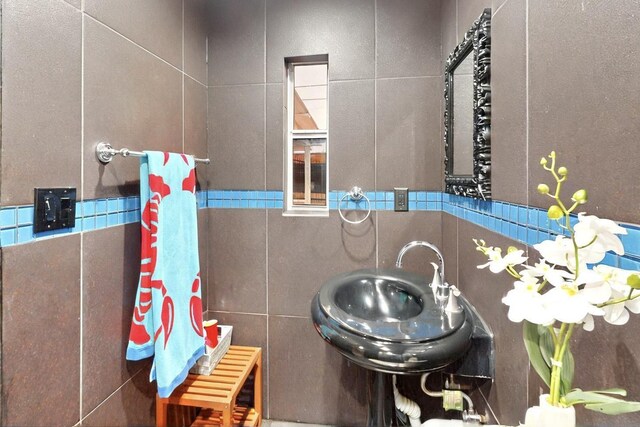 2241 Riviera Dr, Dallas, TX 75211 - half bath featuring tile walls, toilet, and a sink