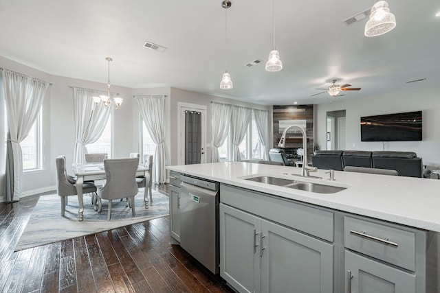 kitchen with a sink, light countertops, plenty of natural light, and stainless steel dishwasher