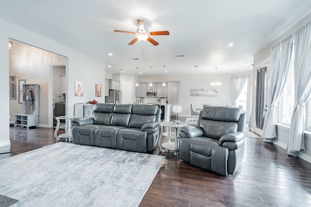 living area with visible vents, baseboards, ceiling fan with notable chandelier, recessed lighting, and dark wood-type flooring