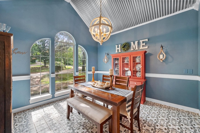 dining space featuring baseboards, high vaulted ceiling, and an inviting chandelier
