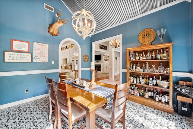 dining room featuring an inviting chandelier, a fireplace, arched walkways, baseboards, and visible vents