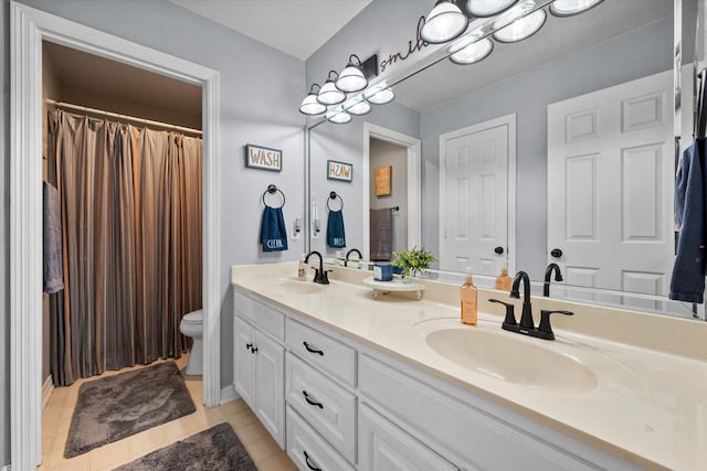 full bathroom with a sink, tile patterned floors, toilet, and double vanity