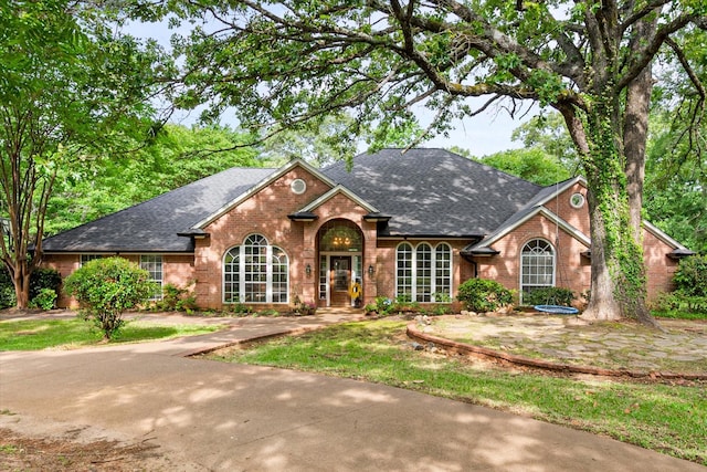 ranch-style home with brick siding and a shingled roof