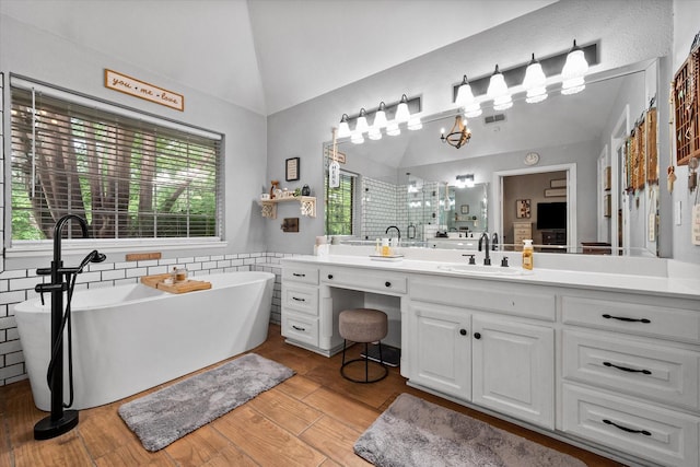 bathroom with plenty of natural light, vaulted ceiling, and a shower stall