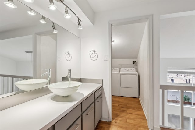bathroom with separate washer and dryer, wood finished floors, and vanity