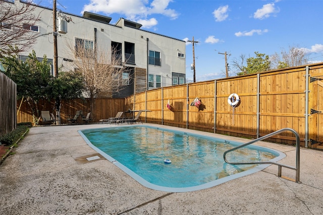 view of swimming pool featuring a fenced in pool, a fenced backyard, and a patio area