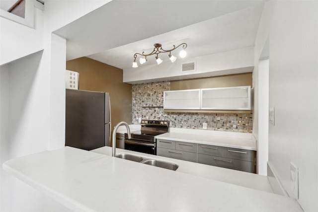 kitchen featuring decorative backsplash, visible vents, appliances with stainless steel finishes, open shelves, and a sink