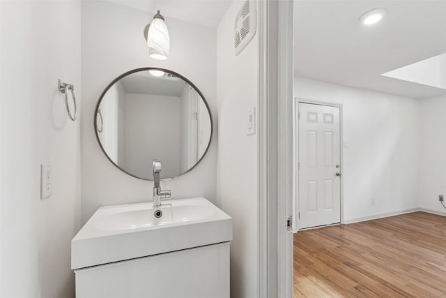bathroom with vanity, recessed lighting, and wood finished floors