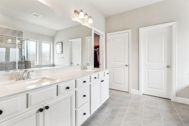 full bath featuring visible vents, a sink, tile patterned flooring, and a stall shower