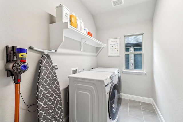 laundry room featuring laundry area, visible vents, baseboards, tile patterned floors, and washing machine and clothes dryer