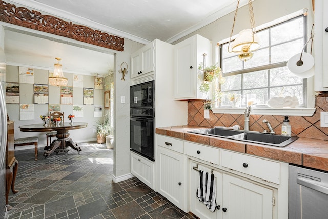 kitchen with backsplash, stone finish flooring, crown molding, a sink, and black appliances