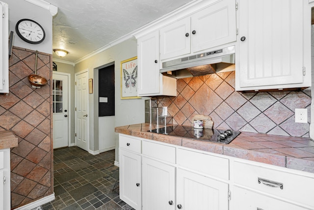 kitchen featuring black electric cooktop, baseboards, ornamental molding, under cabinet range hood, and white cabinetry