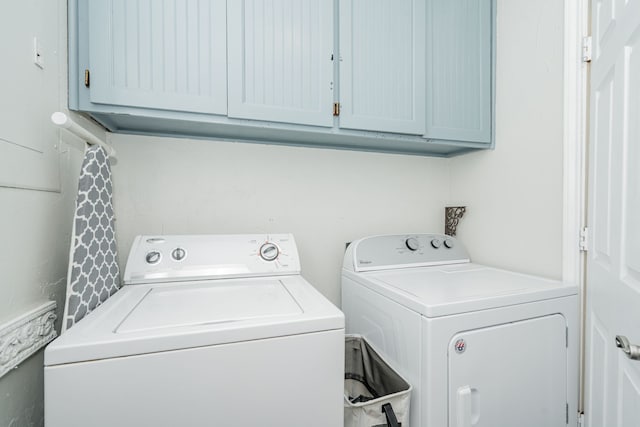 laundry area featuring separate washer and dryer and cabinet space