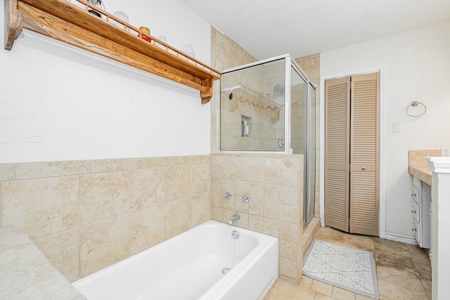 bathroom featuring a closet, a garden tub, a stall shower, and vanity