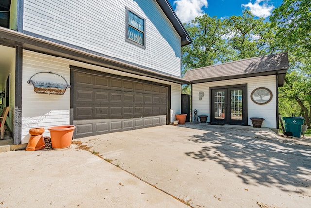 garage with french doors and driveway