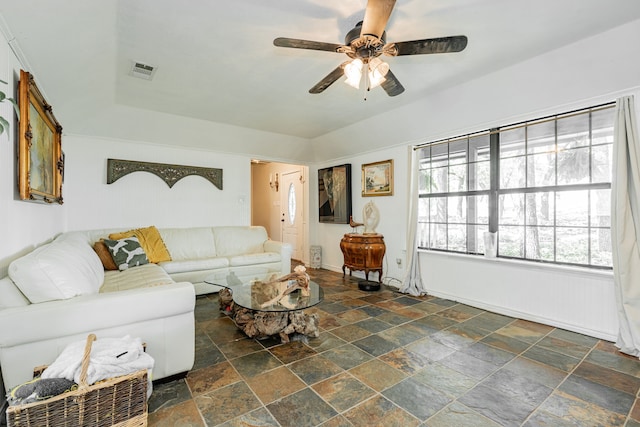 living room with stone tile floors, a ceiling fan, and visible vents