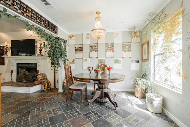 dining area featuring stone tile flooring, visible vents, baseboards, a fireplace with raised hearth, and a notable chandelier