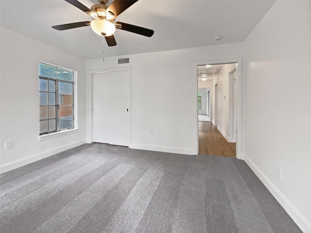 unfurnished bedroom with carpet flooring, a ceiling fan, baseboards, visible vents, and a closet